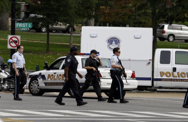 U.S. Park Police and DC Metro police walk with weapons on Capitol Hill in Washington, Thursday, Oct. 3, 2013.  A woman driving a black Infiniti with a young child inside tried to ram through a White House barricade Thursday, then led police on a chase that ended in gunfire outside the Capitol, witnesses and officials said. (AP Photo/Alex Brandon)