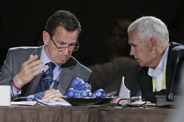 Connecticut Gov. Dan Malloy, left, talks with Indiana Gov. Mike Pence, right, during a meeting on jobs and education at the National Governors Association convention Saturday, July 12, 2014, in Nashville, Tenn. (AP Photo/Mark Humphrey)
